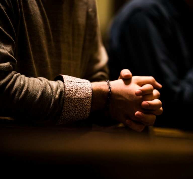 two people holding hands while sitting at a table
