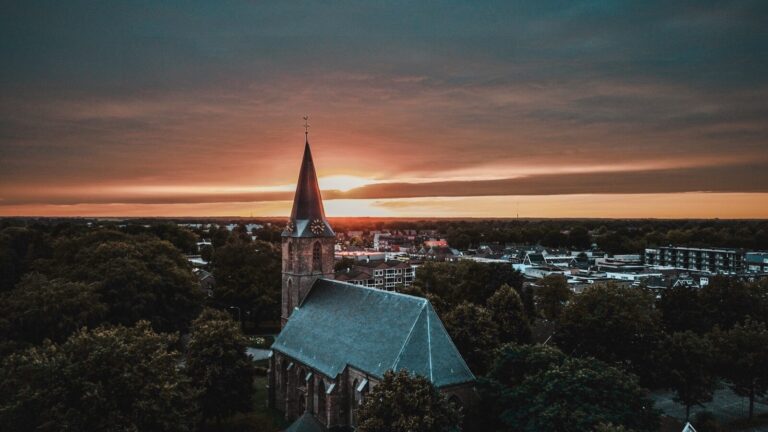a church steeple with a sunset in the background
